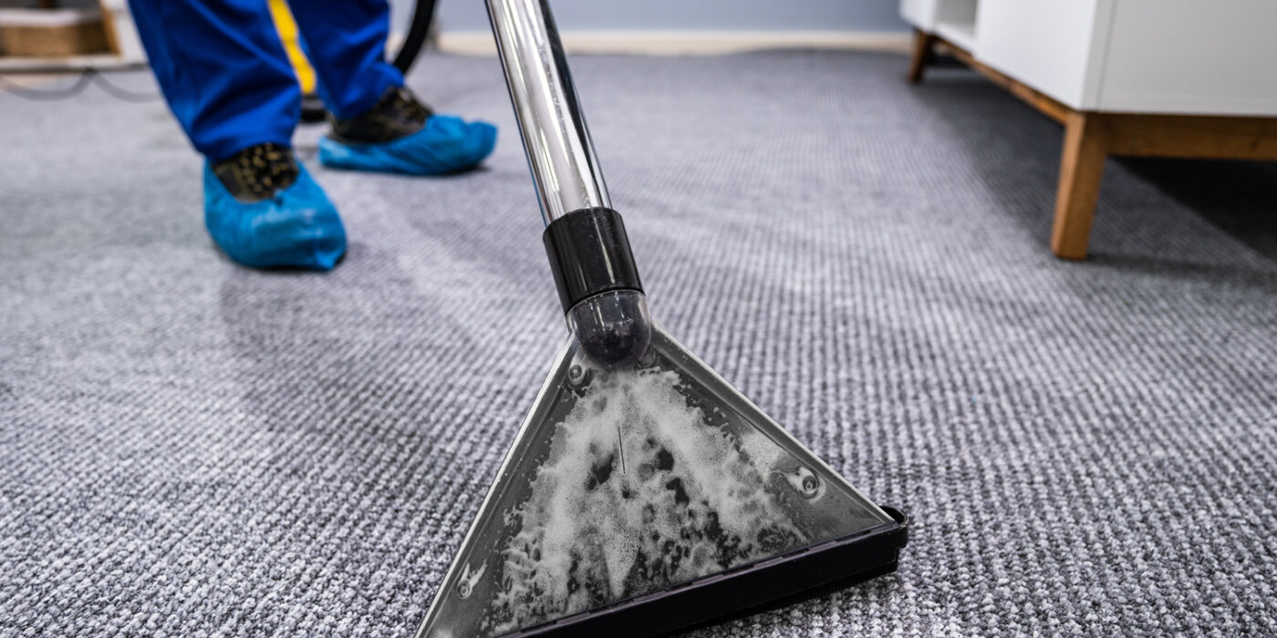 worker cleaning carpet